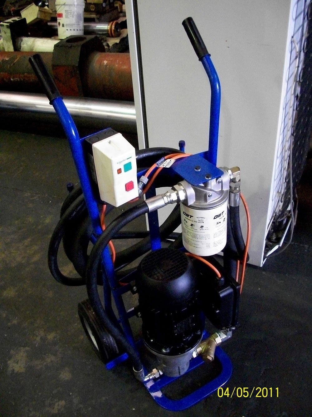 Industrial filtration cart with compressor and hoses in workshop